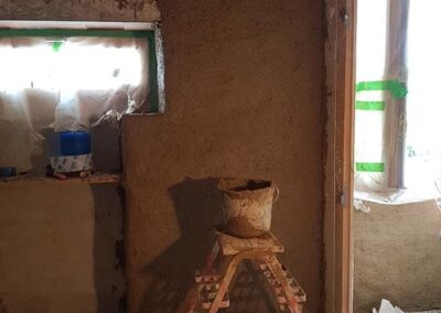 Réalisation d'un correcteur thermique en terre paille chaux sur un gobetis (mur en pisé)
